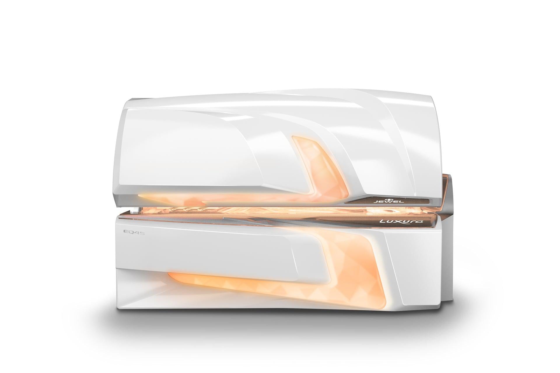 Front view of the Luxura Jewel EQ45 tanning bed with a sleek white exterior and warm amber Crystal Light illumination glowing through the sculpted panels.