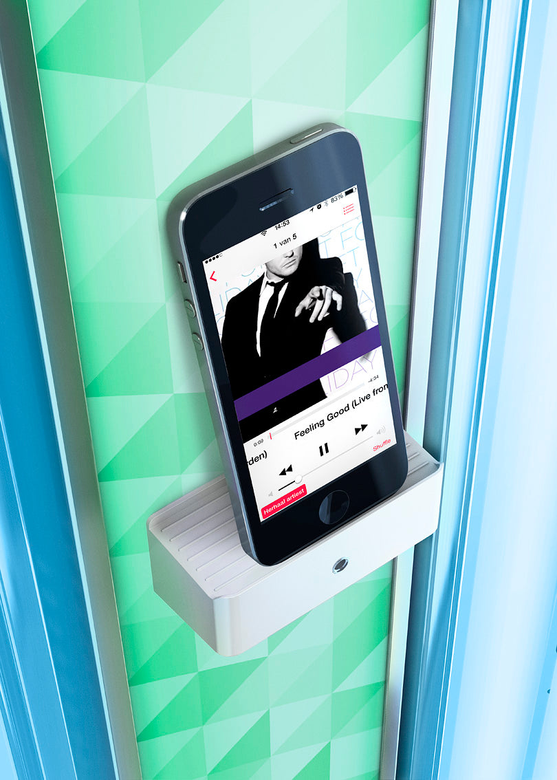 Close-up of the Luxura V8 phone holder mounted on the patterned green centre column with a smartphone docked for audio playback.