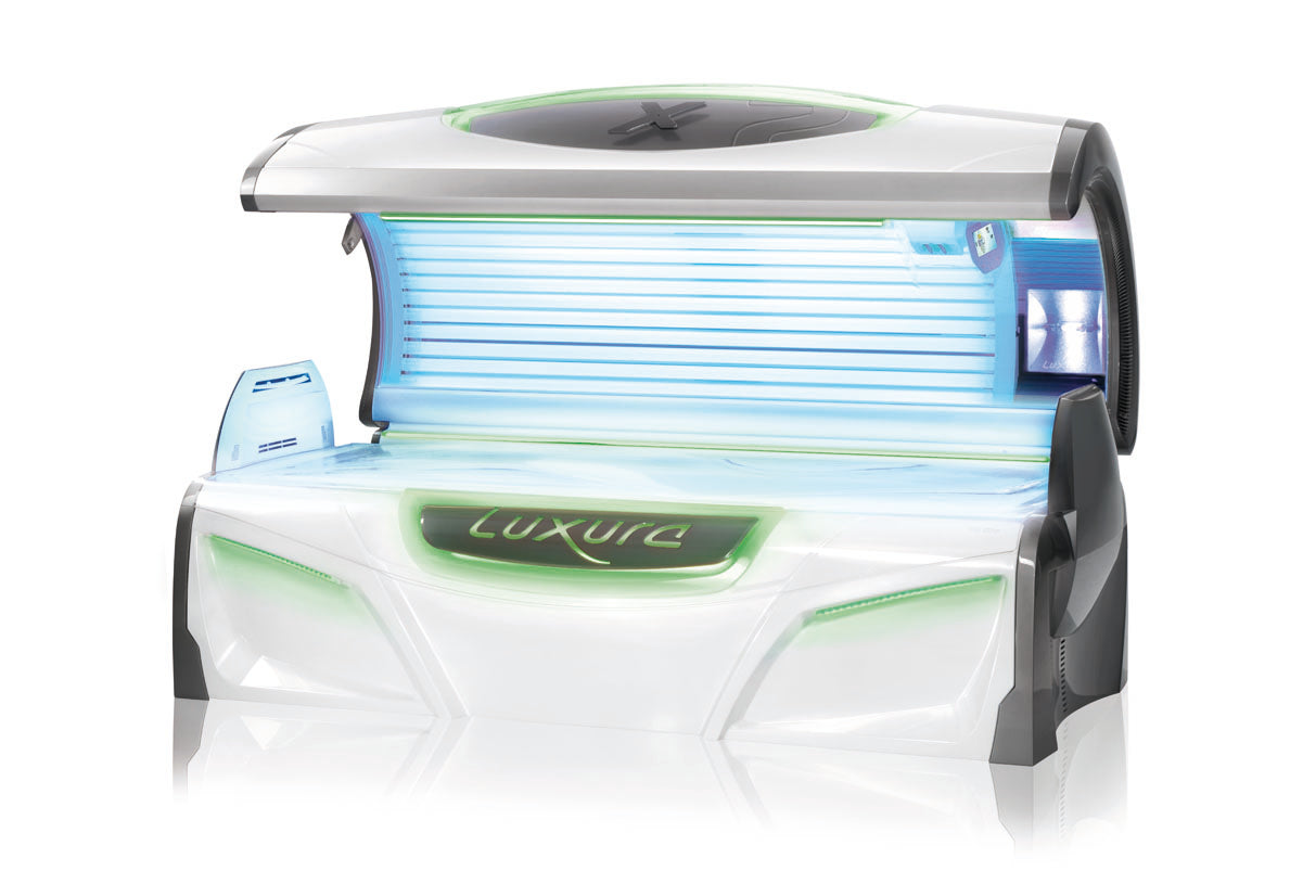 Luxura X7 tanning bed shown fully open with bright blue tanning lamps and green FlowLight LED accents across the body.